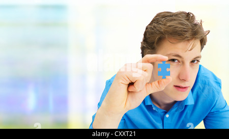 Junger Mann mit einem Stück eines Puzzles Stockfoto