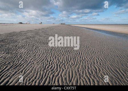 Strand von Sankt Peter-Ording in der Morgensonne bei Ebbe mit Pfahlbauten am Horizont auf Rückseite, Nordseestrand Stockfoto