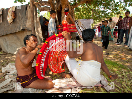 Männer, die Vorbereitung der Maske Theyyam Künstler vor der Zeremonie, Thalassery, Indien Stockfoto