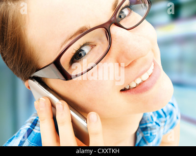 Mädchen mit Brille auf dem Handy an einer u-Bahnstation sprechen Stockfoto