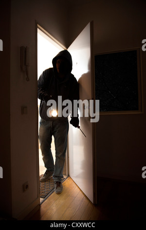 Einbrecher bricht in eine Wohnung. Symbol-Bild. Stockfoto