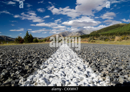 Weiße Markierungen auf einer Straße mit groben Asphalt, Wurm Auge Ansicht, Arthurs Pass Road, Südinsel, Neuseeland, Ozeanien Stockfoto