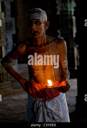 Priester mit traditionellen Malerei auf der Stirn mit einer Kerze im Airavatesvara-Tempel in Darasuram, Indien Stockfoto