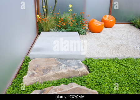 Moderner, zeitgenössischer englischer kleiner Innenhof mit Kiesgarten mit Steinblöcken und modernem Sitzbereich, Terrasse, Chelsea-Blumenschau, Großbritannien Stockfoto