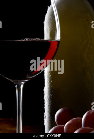 Rotweinglas, Flasche Wein und Trauben Stockfoto