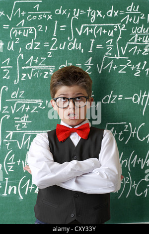 Schuljunge Brillen-und eine Fliege vor einer Tafel mit mathematischen Gleichungen Stockfoto