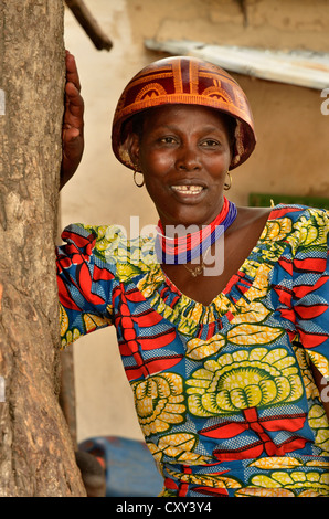 Trägerin des Kalebasse-Helms, die typisch für die Region und ein buntes Kleid, Dorf Tourou, Kamerun Stockfoto