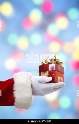 Santa Claus, Detail aus einem Arm Übergabe ein Weihnachtsgeschenk Stockfoto