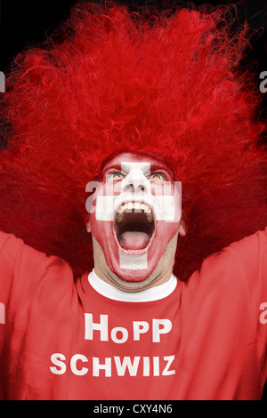 Jungen Mann, Fußball-Fan mit einem gemalten Gesicht, Schweizer Nationalflagge, trägt ein rotes T-shirt, Schriftzug "Hopp Schwiiz" schreien Stockfoto