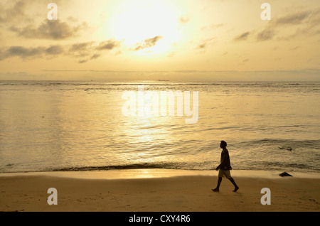 Mann zu Fuß am Strand bei Sonnenuntergang, in der Nähe von Kribi, Kamerun, Zentralafrika, Afrika Stockfoto