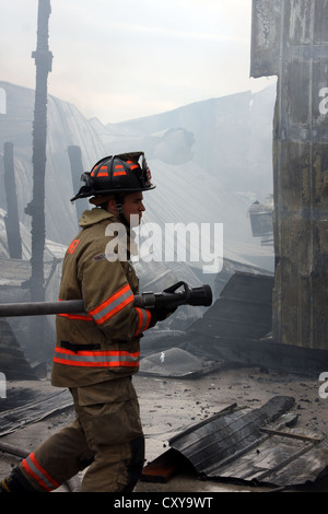 Ein Feuerwehrmann hält ein Maschinist bei der Feuer-Szene Stockfoto