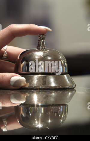 Hand, Finger auf einer Hotel-Rezeption-Glocke Stockfoto