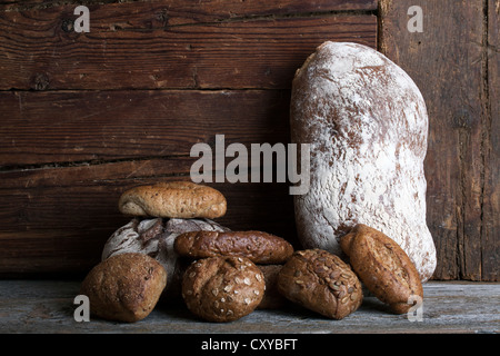 Brot und Brötchen auf einer rustikalen Holzoberfläche Stockfoto