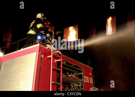 Feuerwehrleute Löschen eines Brandes von einem Feuerwehrauto Stockfoto