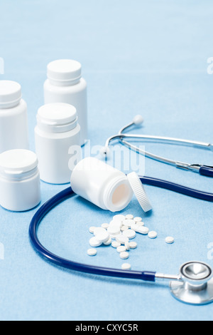 Medizintechnik, verschüttete Tabletten und Stethoskop auf blauem Hintergrund Stockfoto
