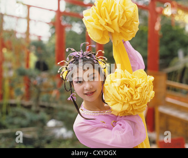 Hong Kong. Nahaufnahme der jungen Frau Tänzer in Tracht. Tragen gelbe Material Röschen. Stockfoto