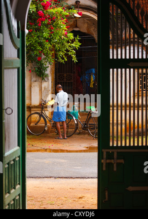 Mann und sein Fahrrad gesehen von A vorbei an alten Hauseingang In Kanadukathan Chettinad, Indien Stockfoto