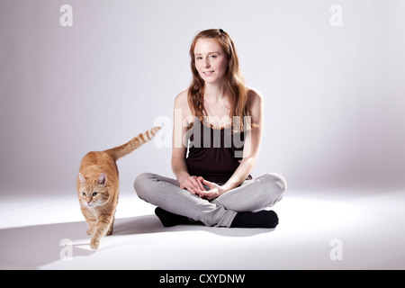 Rothaarige Frau und eine rote Katze Stockfoto