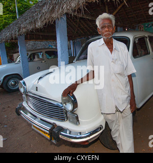 Alter Mann mit grauem Haar posiert stolz vor einem berühmten indischen Auto namens den Botschafter, Trichy, Indien Stockfoto