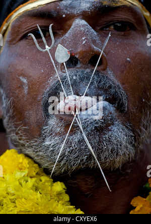 Mann fallenden Asche mit Gipfeln, die als Symbol für Gods'weapons In seine Zunge bei Brand zu Fuß Ritual, Madurai, Süd-Indien Stockfoto