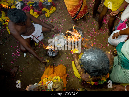 Sittinge Menschen mit Opfergaben hinter ihnen vorbereiten Gläser auf Feuer Feuer zu Fuß Ritual, Madurai, Süd-Indien Stockfoto