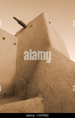 Taos, New Mexico, Kirche San Francisco De Asis, abgeschlossen 1816, Adobe Wand- und Kirchenglocke Detail. Stockfoto