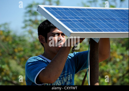 Junger Mann Berg Solarzellen auf dem Dach eine einfache Hütte ein wirtschaftender Bauernhof, Gran Chaco, Provinz Santiago Del Estero Stockfoto