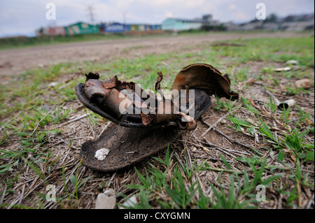 Alte Leder Sandale liegend auf einem Fußballfeld, Lomas de Santa Faz Slum, Guatemala City, Guatemala, Mittelamerika Stockfoto