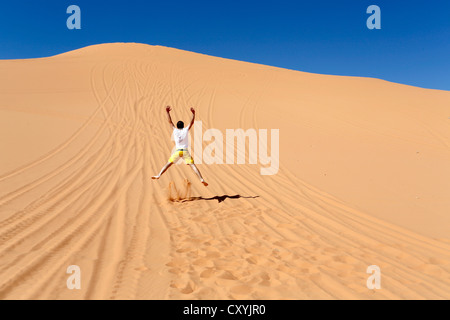Mann springt in den Sand der Dünen in Coral Pink Sand Dunes State Park in der Nähe von Kanab, Utah, USA Stockfoto