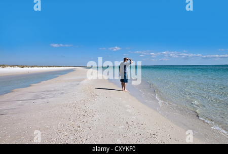 Ein Mann auf einem langen einsamen Strand, Blick auf das Meer. Stockfoto