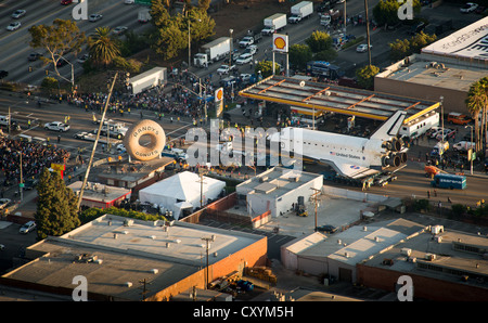 Luftbild zeigt das NASA Spaceshuttle Endeavour neben der Randy Donuts Wahrzeichen in Inglewood während auf einer 12-Meilen-Reise auf der Straße zu seinem neuen Haus an der California Science Center 12. Oktober 2012 in Los Angeles, Kalifornien. Endeavour 25 Missionen abgeschlossen, verbrachte 299 Tage im Orbit und umkreiste die Erde 4.671 Zeiten während der Reise 122,883,151 Meilen. Ab 30. Oktober das Shuttle werden auf dem Display in der Samuel erste Space Shuttle Endeavour anzeigen Pavillon. Stockfoto