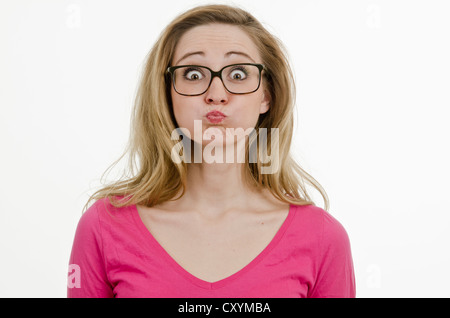 Junge Frau, 25, mit großer Brille, mit gepufften Wangen und ihre Augen weit offen Stockfoto