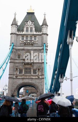 Menschen zu Fuß auf Tower Bridge, im Regen, unter ihren Regenschirmen Stockfoto