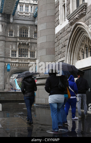 Menschen zu Fuß auf Tower Bridge, im Regen, unter ihren Regenschirmen Stockfoto
