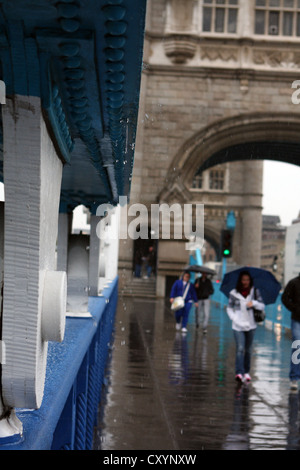 Menschen zu Fuß auf Tower Bridge, im Regen, unter ihren Regenschirmen Stockfoto