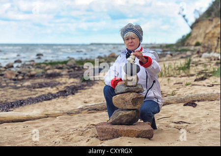 Frau bauen ein Steinhaufen am Strand, Timmendorf auf der Insel Poel, Mecklenburg-Vorpommern Stockfoto