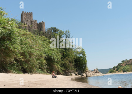 Frau sitzt in der Nähe der Burg von Almourol mitten in den Fluss Tejo, Portugal Stockfoto