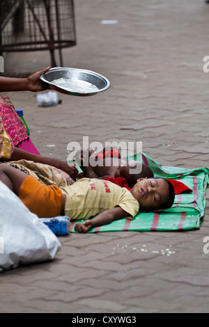 Kinder auf der Straße in Kalkutta schlafen, während Mutter bettelt, Indien Stockfoto