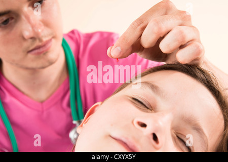 Kinderarzt, ein junges Mädchen mit Akupunktur behandeln Stockfoto