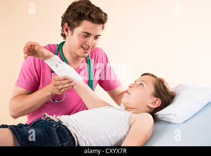 Mädchen mit ihren Arm bandagiert von ihrem Kinderarzt Stockfoto