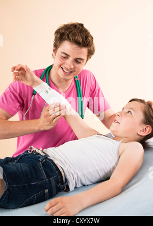 Mädchen mit ihren Arm bandagiert von ihrem Kinderarzt Stockfoto