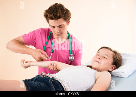 Mädchen schauen beim Abrufen einer Nadel aus ihrem Kinderarzt Angst Stockfoto