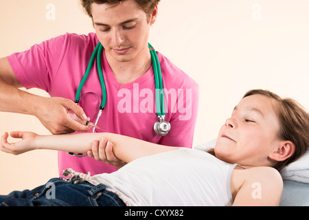 Mädchen schauen beim Abrufen einer Nadel aus ihrem Kinderarzt Angst Stockfoto