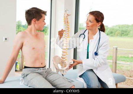 Orthopädischer Chirurg, ein Teenager zu erklären, ein Modell der Wirbelsäule Stockfoto