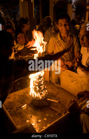 Hinduistischen Anbeter übergeben ihre Hände durch ein heiliges Ritual Flamme am Vishram Ghat, Mathura, Indien Stockfoto