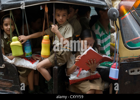 Schülerinnen und Schüler fahren zur Schule Sie in eine Autorikscha in Mathura, Indien Stockfoto