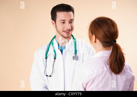 Junger Arzt in Absprache mit dem Patienten Stockfoto