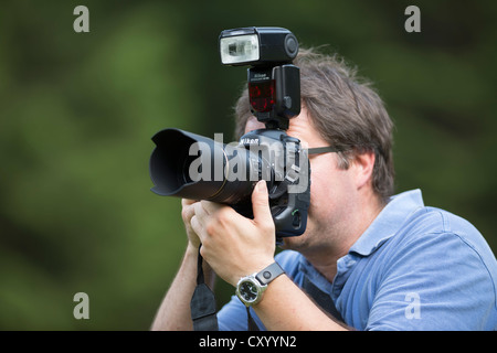 Fotograf, Mitte 40, fotografieren, Blick durch den Sucher einer SLR-Digitalkamera Nikon D4 mit einem Schuh montiert Stockfoto
