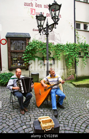 Zwei deutsche Musiker spielen die Balalaika und das Akkordeon in der alten Stadt Traben-Trarbach, Deutschland im Rheinland. Stockfoto