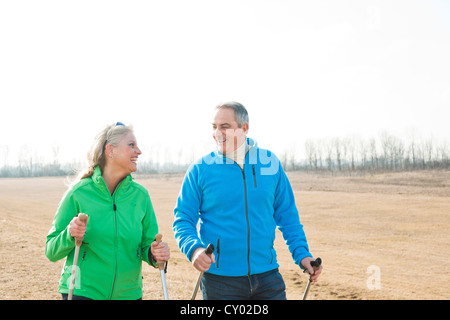 Lächelnd älteres Paar tun, Nordic-walking Stockfoto